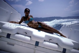 Sexy girl female model in blue bikini onboard powerboat