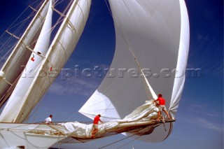 Crew tend to a sail change on the bow of classic yacht Adela