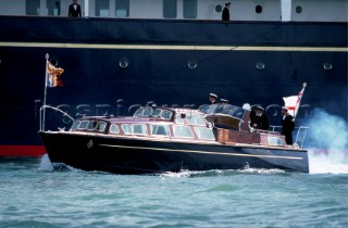 Naval officers manoeuvre the tender to the Royal motor yacht Britania in Cowes, Isle of Wight