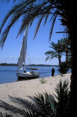 Man stands by his felucca on the river Nile southern Egypt
