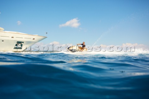 Man jet skiing in the mediterranean sea near a superyacht