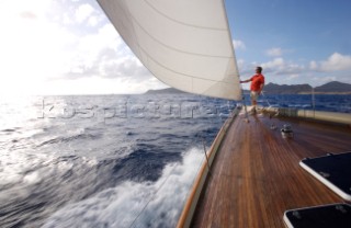 A man stands on the bow of the W-Class yacht Wild Horses near St. Bartholomew, French West Indies.