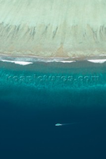 Aerial view of boat traveling along the edge of an atoll, Meemu Atoll, Maldives, on 5 November 2007. The Maldives is made up of 1200 islands with an average height above sea level of 1.2 metres. The 200 locally populated islands and 90 resort islands are threatened by global warming and rising sea levels.