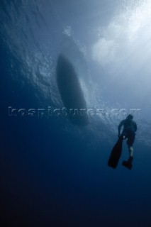 A view of a free diver underwater as he returns to the boat floating above in Costa Rica.