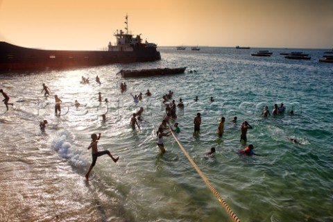 Children bathing on the beach Stone Town Zanzibar