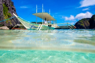 Outrigger boat anchored at Talisay Beach, Tapiutan Island, El Nido, Palawan, Philippines
