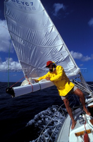 Crew member reefs the mainsail