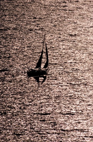 Lone yacht sailing on textured sea