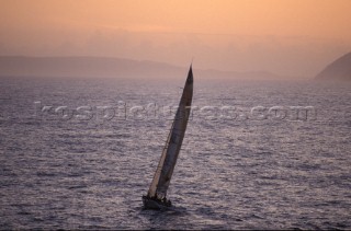 Yacht sailing into the sunset on a calm open sea