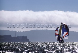 Yacht sailing with spinnaker and blooper past Alcatraz in San Francisco Bay