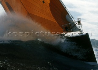 Waves flying from bow maxi yacht