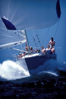 Yacht under spinnaker power through the water down wind