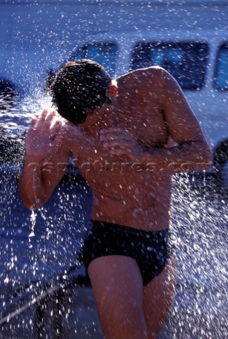 A man is soaked by water from a hose pipe