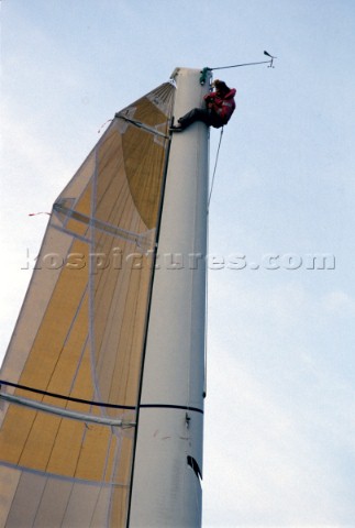 Crew member carries out repairs at the top of a mast