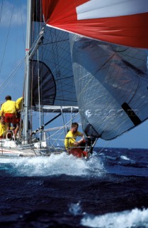 Crew close to water on bow of yacht in choppy seas