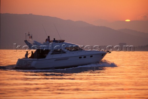 Powerboat heading out to sea at sunrise