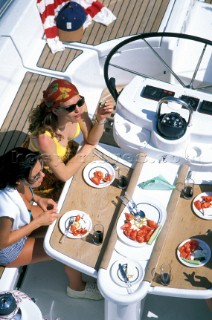 People eating round a table in the cockpit of a sailing yacht