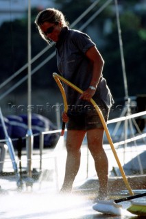 Female crew member washes the deck of Wally yacht Tiketitoo