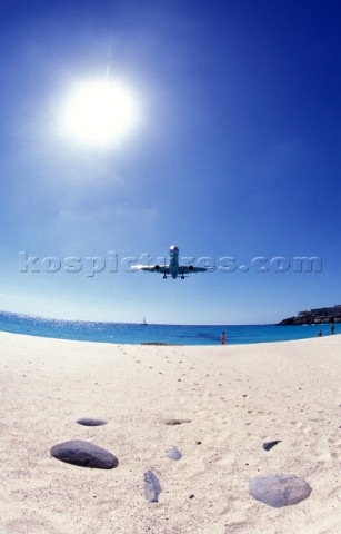 Plane arriving at St Martin airport next to beach