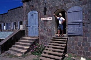 Man standing in doorway of Poice station, Nevis, Caribbean