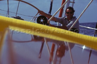 Man helming a large sailing yacht
