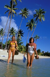 Two women walk through shallow water at Muske Cove, Fiji