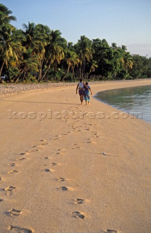 A couple walking along Blue Lagoon Beach Fiji