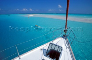 Snorkellers and bow of cruising yacht - French Polynesia.