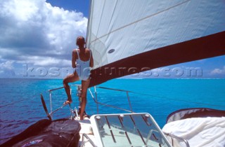 Woman standing on bow of cruising yacht
