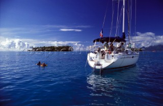 Children swimming off an anchored yacht, French Polynesia