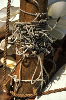 Detail of flaked sail and knotted ropes on traditional sailing boat