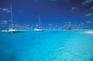 Two cruising catamarans anchored in clear, shallow water - Seychelles