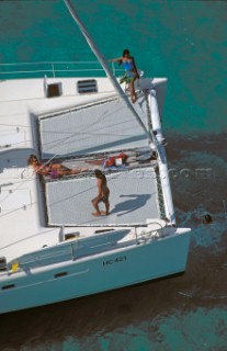 People relaxing onboard a cruising catamaran.
