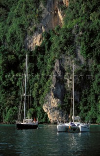 Cruising yachts anchored in a secluded bay off the coast of Phuket in Thailand