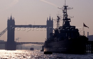 HMS Belfast at sunset on the river Thames in London infront of the citys famous Tower Bridge.