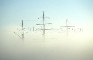 Masts and rigging of a tall ship covered by mist