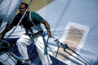 Crew member hangs on to rail of racing yacht