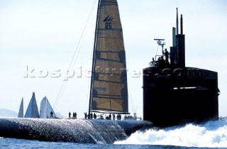 A naval submarine ploughs through the middle of a yacht race course