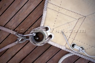 Detail of clew of classic sail on teak deck
