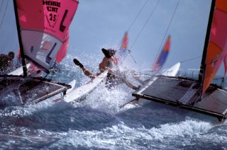 Two Hobie Cats crashing through rough seas in strong wind