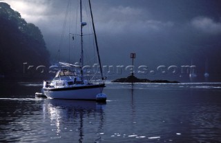 Yacht moored on the River Dart on a tranquille morning by the Anchor Stone at Dittisham