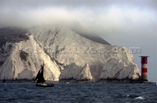 Yacht sailing in mist at the Needles, Isle of Wight, UK