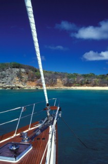 Foredeck of sailing yacht anchored off sandy beach - St Martin, Caribbean
