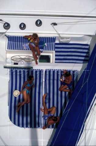 Family relaxing in a large cockpit of a charter catamaran