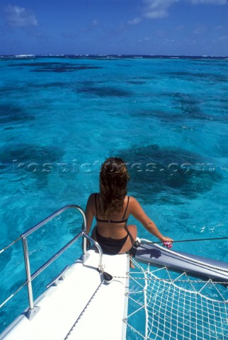 Girl sitting on bow of catamaran