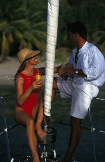 A couple relax on board an anchored yacht