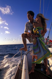 A couple look out to sea onboard a sailing yacht