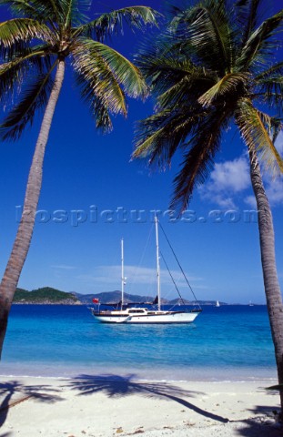 Yacht at anchor off tropical beach  Cruising yacht anchored off beach in shallow water Caribbean 