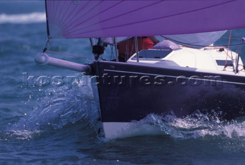 Bow detail of J80 racing  boat sailing down wind under asymmetric spinnaker