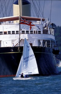 A dinghy sails passed the bow of the Royal yacht Britania in the Solent, UK